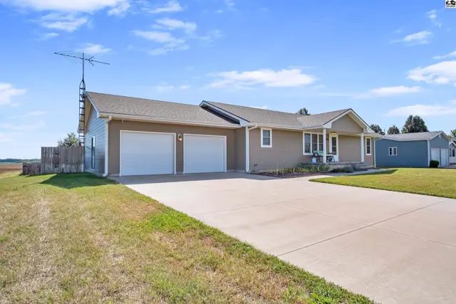 This tan ranch-style home features a concrete driveway and a two-car garage.