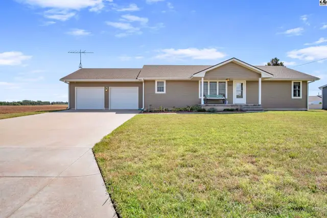 This tan ranch-style home features a two-car garage and a covered front porch.