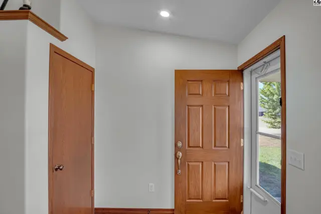 Interior entryway features a wood-paneled door and a closet door.