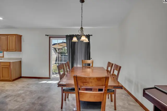 This dining area features a wooden table, chairs, and a pendant light.