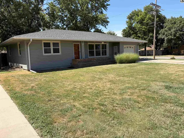 This single-story home features a gray exterior, a covered porch, and an attached garage.