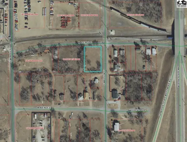 This aerial view shows a parcel of land with surrounding residential structures and infrastructure.
