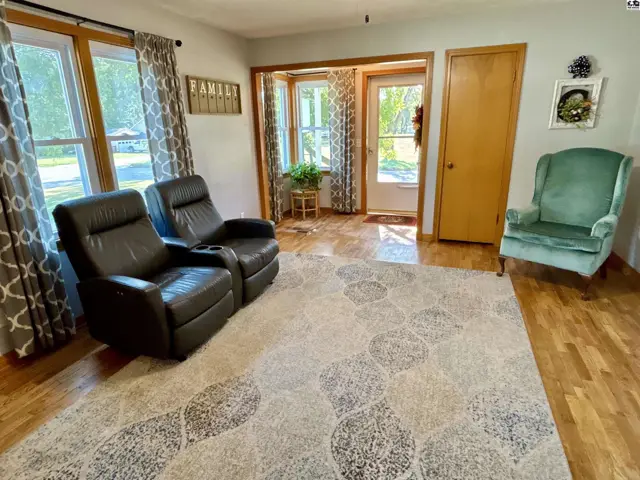 Living room features hardwood floors, a large area rug, and two recliners.