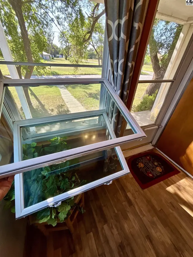 A screened-in porch features a large window and a wood-paneled door.