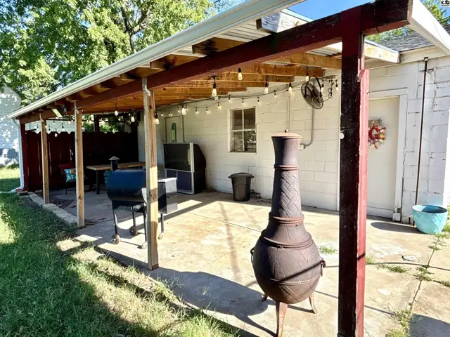 Covered patio with concrete floor, outdoor grill, and decorative chiminea.