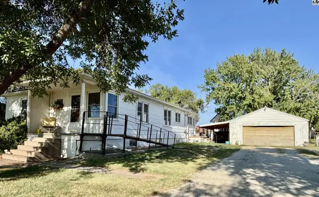 White siding home with a covered front porch and a detached two-car garage.