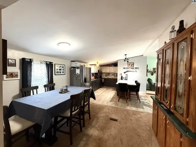Open-concept living area with dining table, kitchen island, and cabinetry.
