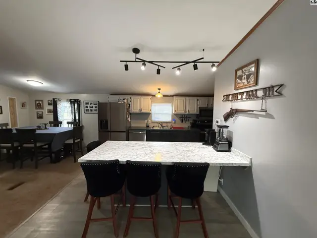 Spacious kitchen with island seating and adjacent dining area.