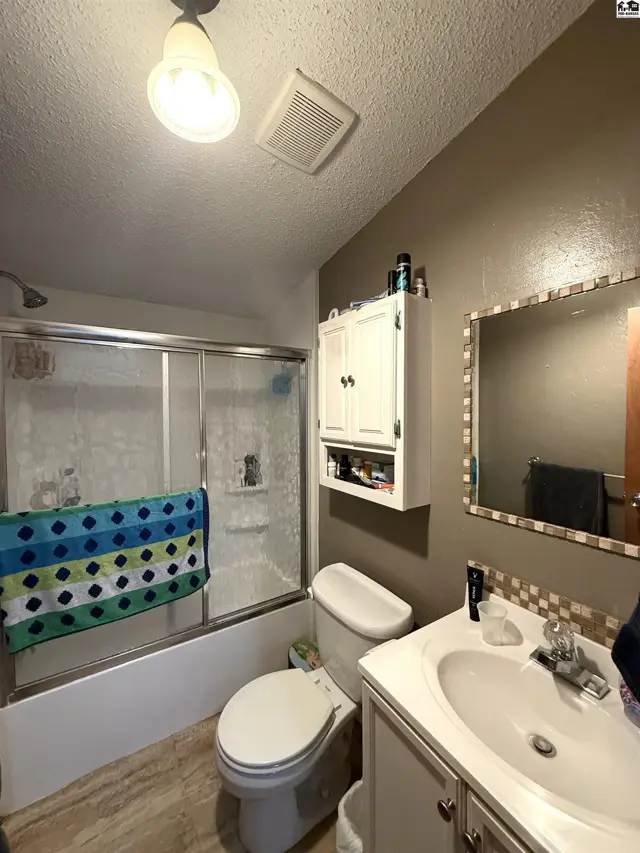 This bathroom features a tub-shower combination, toilet, and vanity with a sink.