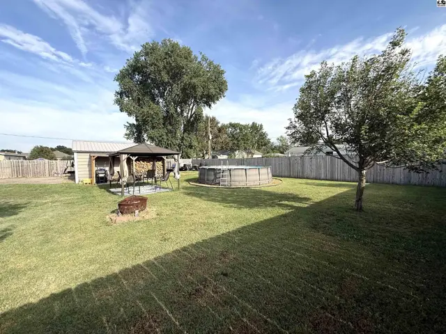 Spacious backyard features a wooden deck, above-ground pool, and fire pit.