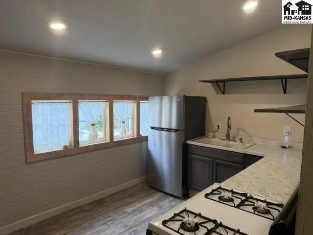 This kitchen features stainless steel appliances, granite countertops, and ample shelving.