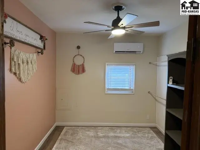 This room features a ceiling fan, air conditioning unit, and a large closet.