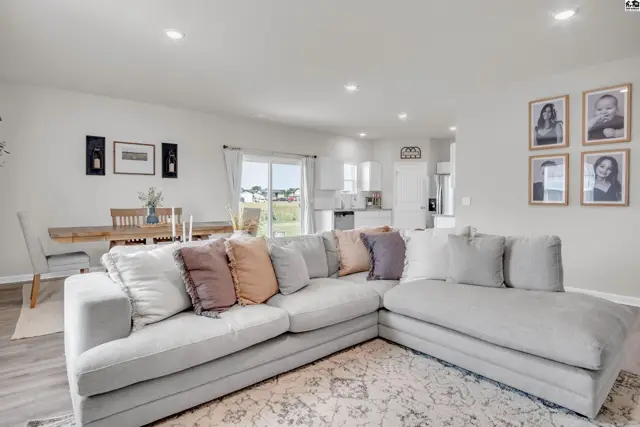 Spacious living area with a sectional sofa, dining table, and open kitchen.