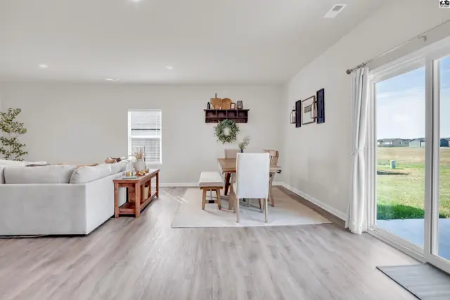 Spacious living and dining area with light wood flooring and a sliding glass door.
