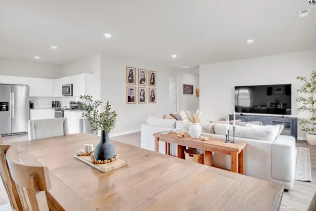 Spacious living area with a dining table, modern kitchen, and comfortable seating.
