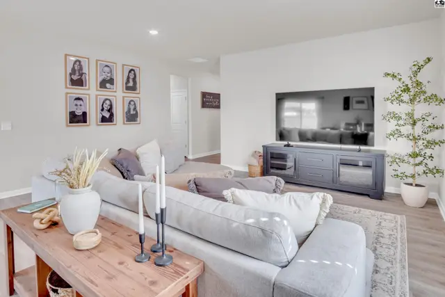 Spacious living room with a large television, comfortable seating, and neutral decor.