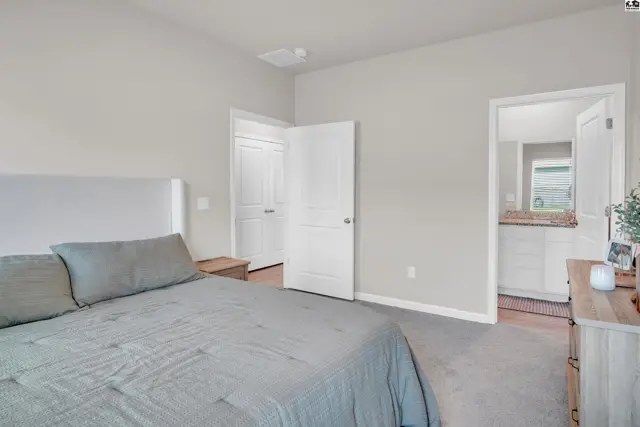 Spacious bedroom with a large bed, closet, and en-suite bathroom.