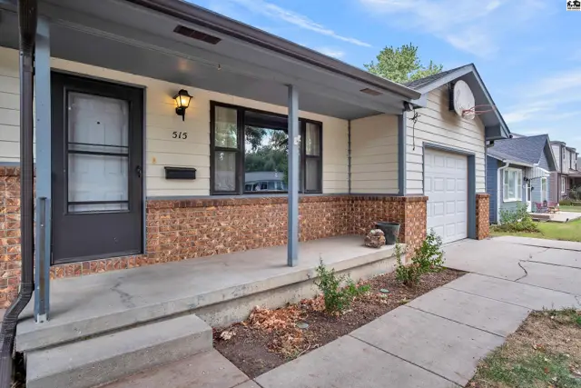 This home features a covered front porch with a concrete walkway and attached garage.
