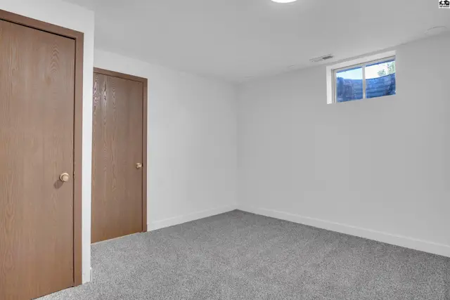 This room features two wood-paneled doors, white walls, and a small window.