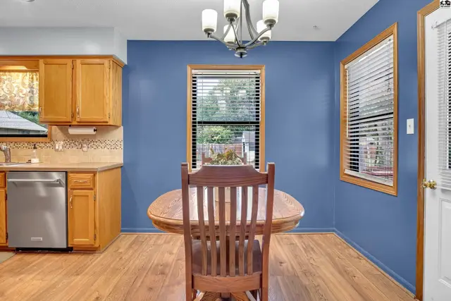This dining area features a wooden table and chairs against blue walls.