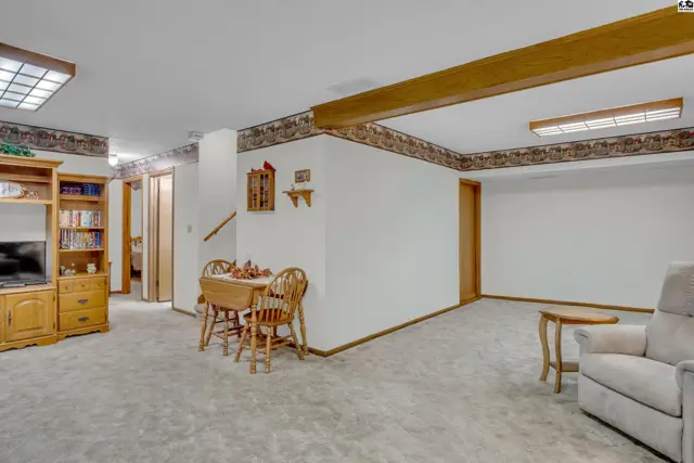 Finished basement with carpet, wood accents, and a small dining area.