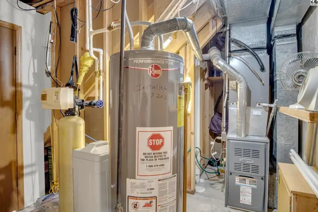 Utility room with water heater, furnace, and water softener.