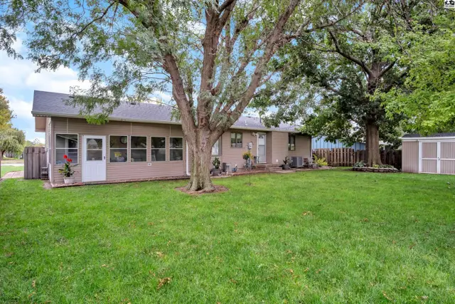 This home features a screened-in porch, a deck, and a large backyard with mature trees.