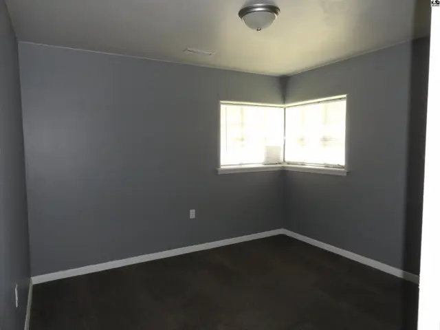 This room features gray walls, a white baseboard, and a ceiling light fixture.