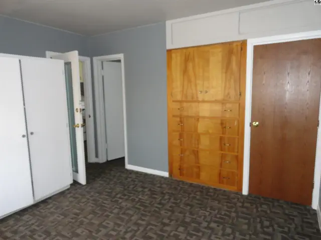 This room features a large built-in wooden wardrobe and two white closet doors.