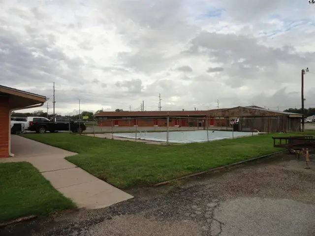 Rectangular swimming pool surrounded by grass and concrete patio.