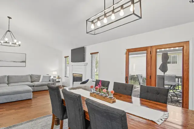 Spacious dining area with a large wooden table and seating, adjacent to a living room with a sectional sofa.
