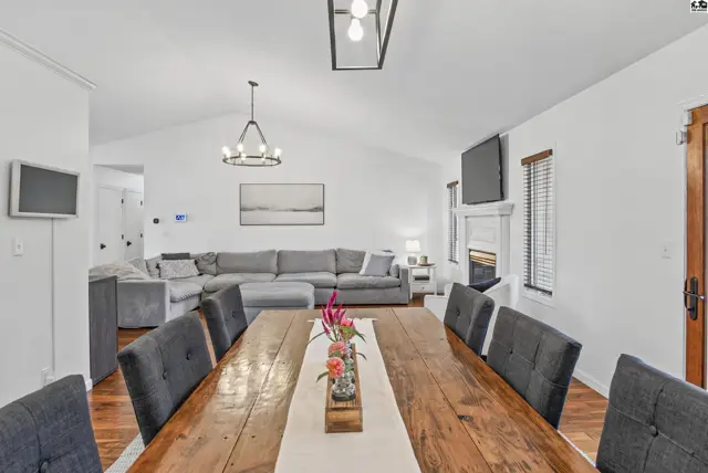 Spacious living and dining areas feature vaulted ceilings, a fireplace, and hardwood floors.
