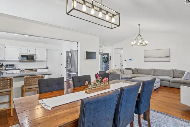 Spacious open-concept living and dining area with a modern kitchen and vaulted ceilings.