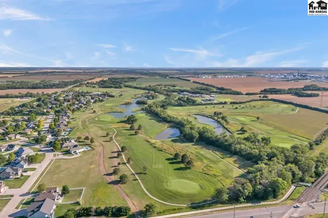Expansive golf course with manicured greens, water features, and surrounding residential development.