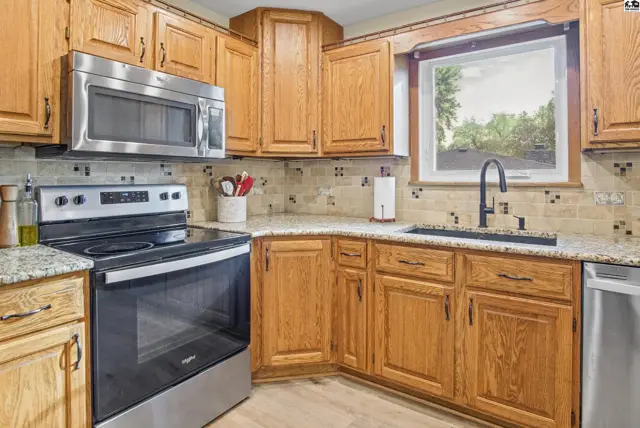 This kitchen features oak cabinetry, granite countertops, and stainless steel appliances.