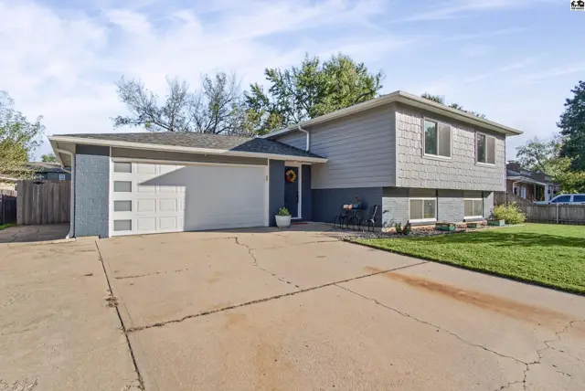 This two-story home features a gray shingle exterior, a two-car garage, and a concrete driveway.