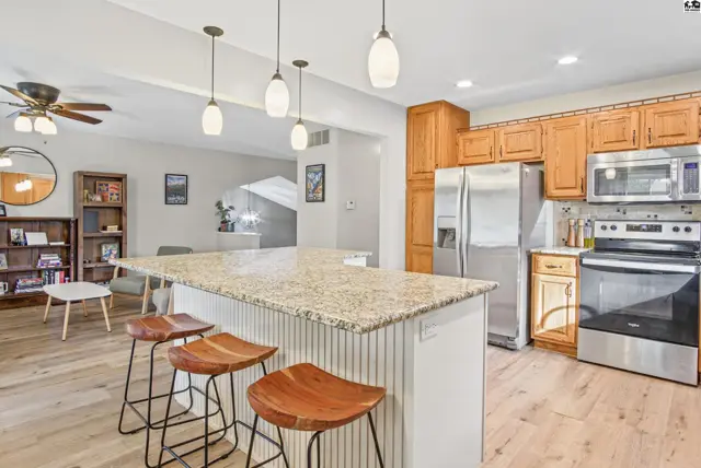 Spacious kitchen features granite countertops, stainless steel appliances, and a large island with seating.