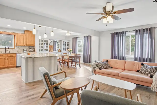 Spacious living area with a kitchen island, dining space, and large windows.