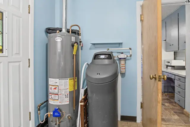 A large water heater and water softener unit are situated next to a doorway.