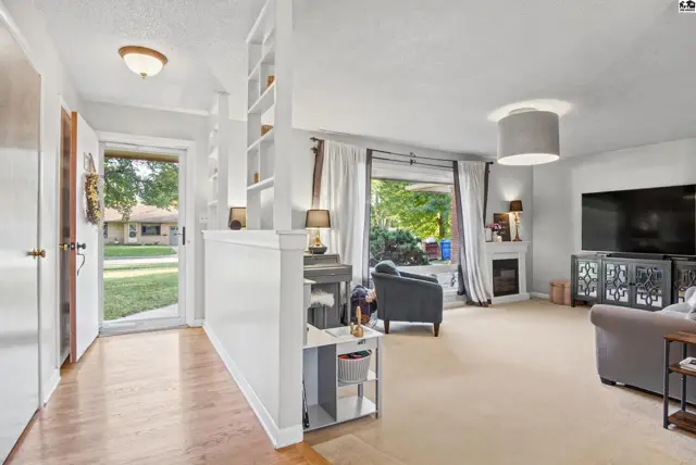 Spacious living area with a fireplace, large windows, and built-in shelving.