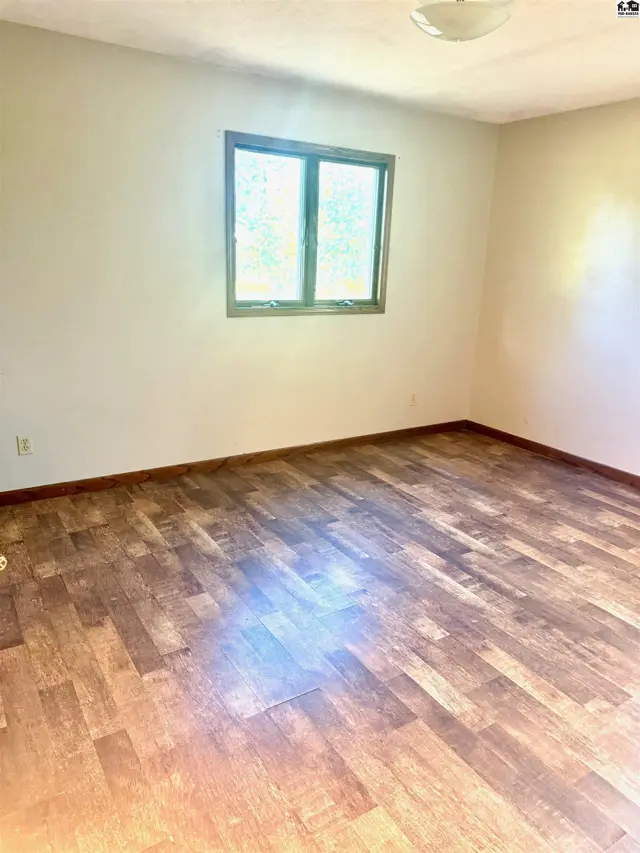 This room features wood-look laminate flooring and a single window.