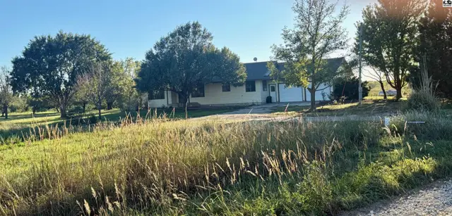 Single-story home with a two-car garage situated on a large, grassy lot.