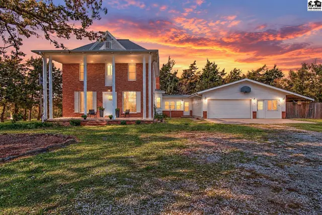 Brick home with a covered front porch and attached two-car garage.