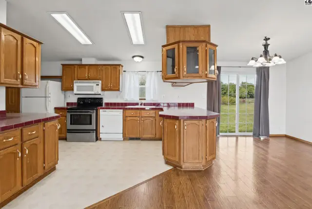 Spacious kitchen features wood cabinetry, a central island, and ample counter space.