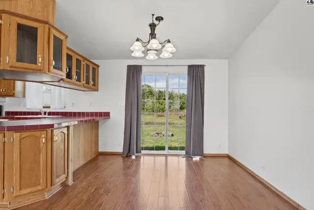 Wood cabinets and a tiled counter define this dining area with a sliding glass door.