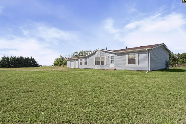 This single-story home features light blue siding and a large grassy yard.