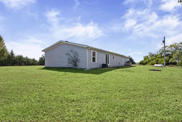Light blue siding and a large grassy yard surround this single-story home.