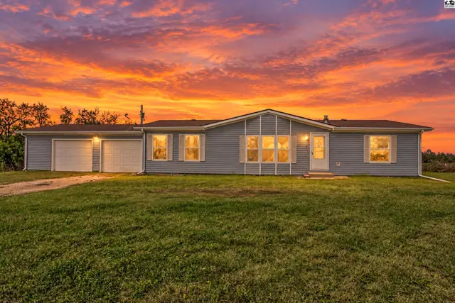 Light blue siding and a white-trimmed roof adorn this single-story home with a two-car garage.