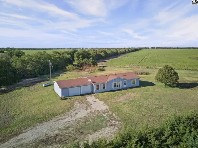 Light blue home with a red roof and attached garage sits on a grassy lot.