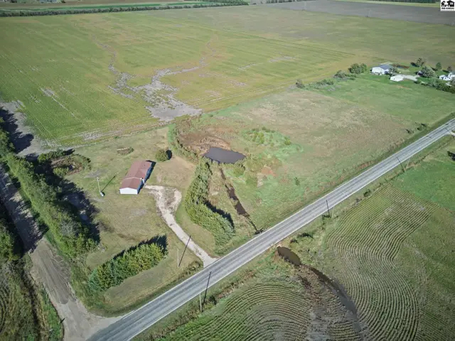 Rural property features a barn, pond, and surrounding agricultural fields.